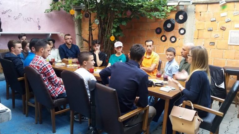Fotografi në grup rreth tavolinës.