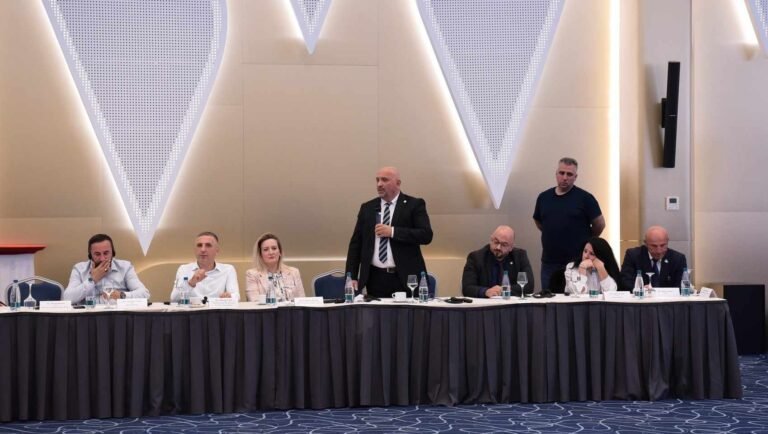 Folës në këmbë pranë një tavoline paneli.